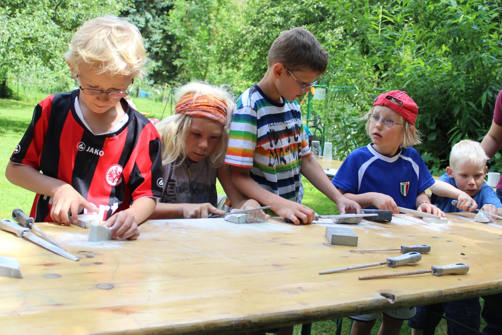 Kindergruppe bei der Specksteinbearbeitung